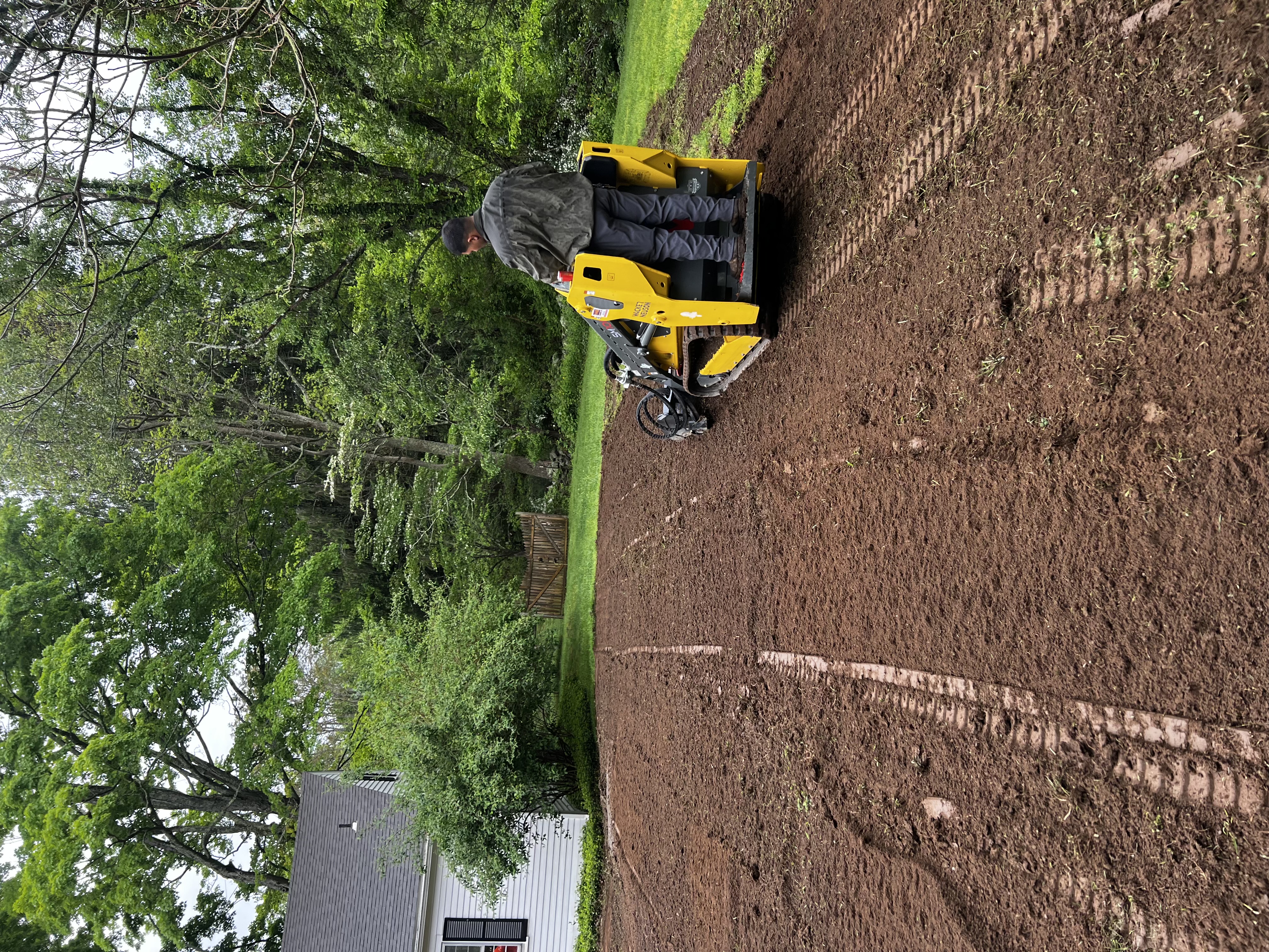 Wacker Neuson mini track loader with tiller attachment stripping and tilling old lawn in Westbrook CT — 6,000 sqft sod prep in progress