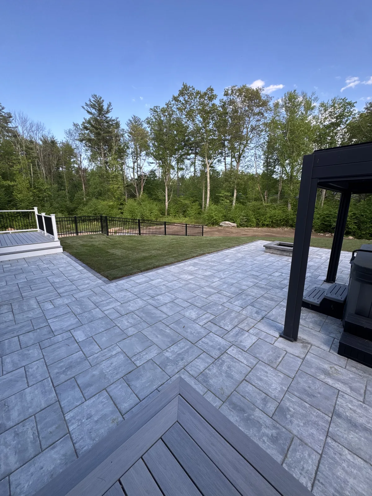 Millbury MA backyard with new Kentucky Bluegrass sod, paver patio, pergola, hot tub, and fire pit installed by CT Sod