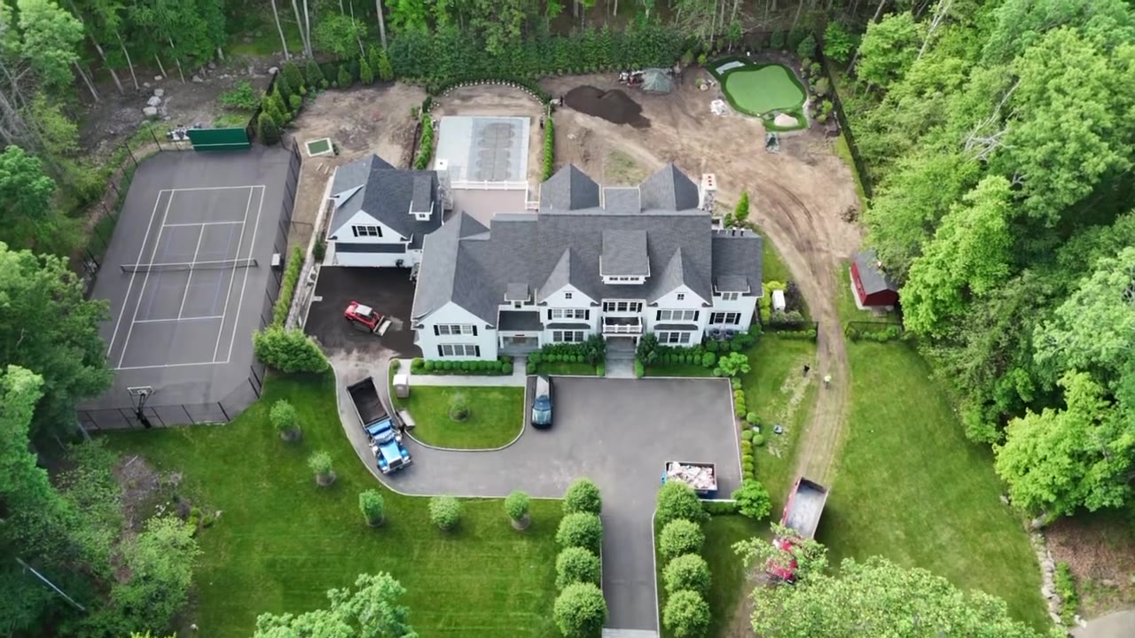 Drone fly-over of a New Canaan, CT estate during sod prep — regraded lawn areas, putting green, and tennis court before fresh-cut sod